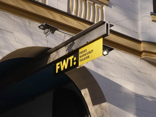 Freies Werkstatt Theater Fotografie des Eingangs zum Freien Werkstatt Theater Köln mit gelbem Schild überm Bogen.Photograph of the entrance to the Free Workshop Theater Cologne with yellow sign above the arch.