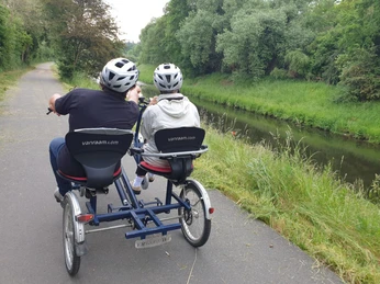 Mutter mit Tochter auf einem Rad für Menschen mit Behinderung