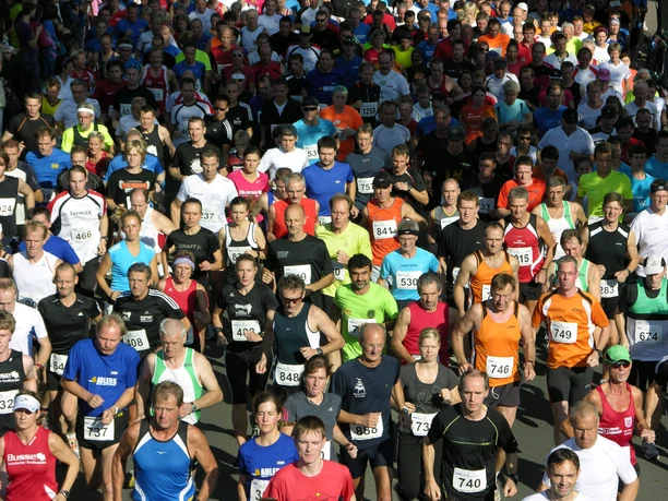 Laufevent-Bad-Zwischenahn.jpg Eine bunte Menge von Teilnehmern in Sportkleidung nimmt an einem Straßenlauf in Bad Zwischenahn teil.