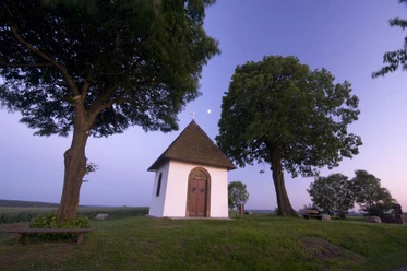 Kluskapelle von außen bei Dämmerung in Pömbsen.