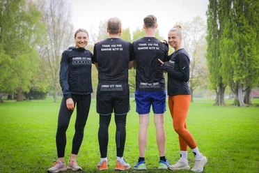 Running tours Leipzig - Running City Tours Four people from Running City Tours stand in sportswear in a park
