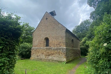 Margarethenklus Wittekindsberg Kapelle aus Sandstein vor dichter Baumkulisse mit schlichter Architektur und einem kleinen Dachreiter.