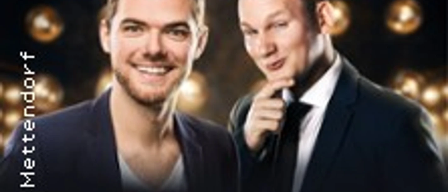 Zwei Entertainer in eleganter Kleidung, umgeben von Lichtern, präsentieren eine Comedy- und Hypnoseshow.