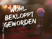Mikrofon auf Bühne mit Schriftzug "WOHL BEKLOPPT GEWORDEN" in hellem Licht; Titel einer Comedy-Show.