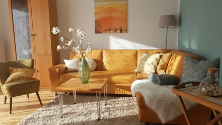 Wohnzimmer mit Sofa, Tisch und Cocktailsessel