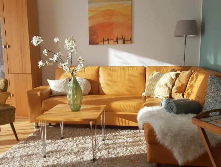 Wohnzimmer mit Sofa, Tisch und Cocktailsessel