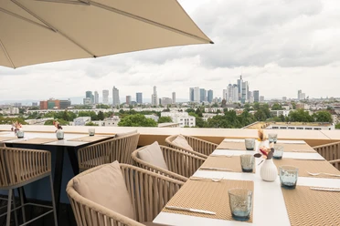 Blasky Dachterrasse mit gedeckten Tischen und Blick auf Skyline Frankfurt