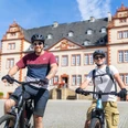 Das Bild zeigt zwei Radfahrer vor dem Schloss Salder