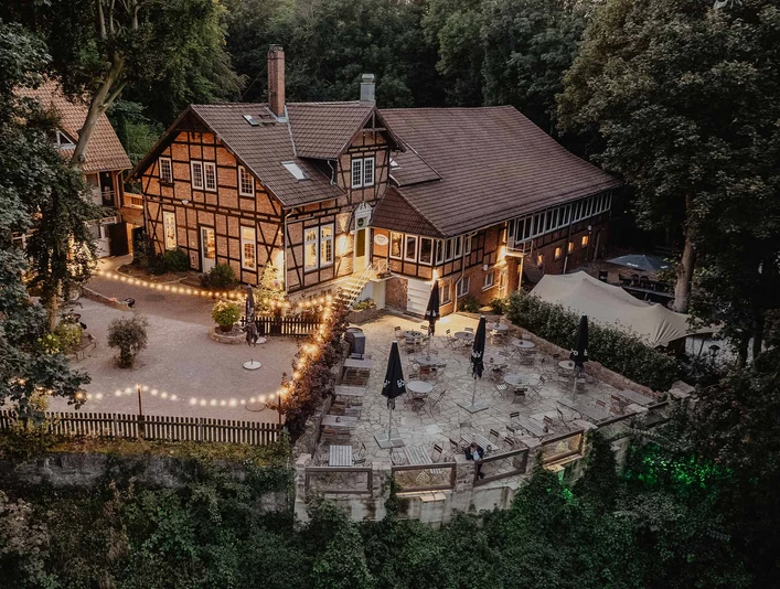 Luftaufnahme des beleuchteten PEAK Hotels in Abendstimmung mit vorgelagerter Aussichtsterrasse in Salzgitter-Lichtenberg