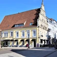 Neustädter Rathaus in Herford mit historischem Brunnen im Vordergrund an einem sonnigen Tag.