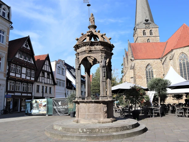 Neustädter Brunnen- Neuer Markt -Pro Herford GmbH.JPG Historischer Brunnen am Neuen Markt mit gotischem Kirchturm im Hintergrund, umgeben von Fachwerkhäusern.