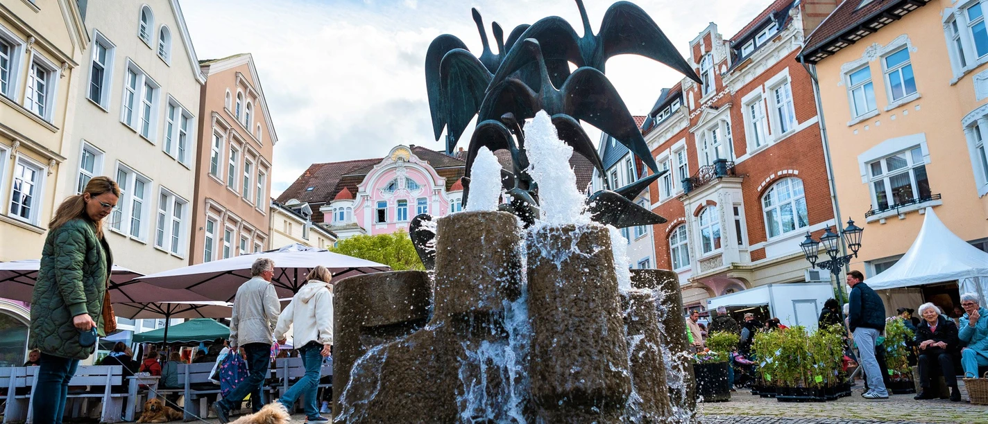 Gänsemarkt Herford beim Herforder Frühling-Pro Herford GmbH.jpg Brunnen mit Wasserspiel und umgeben von historischen Gebäuden auf dem lebhaften Gänsemarkt in Herford.