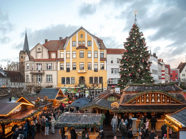 Alter Markt zum Weihnachtsmarkt-ProHerford GmbH.jpg Weihnachtsmarkt mit festlich beleuchteten Buden, bunten Lichtern und einem großen geschmückten Tannenbaum.