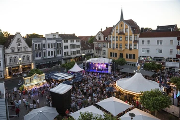 Alter Markt - Herford Hoekerfest-Pro Herford GmbH.jpg Menschenmenge genießt ein Musikfestival auf einem städtischen Platz mit historischen Gebäuden im Hintergrund.