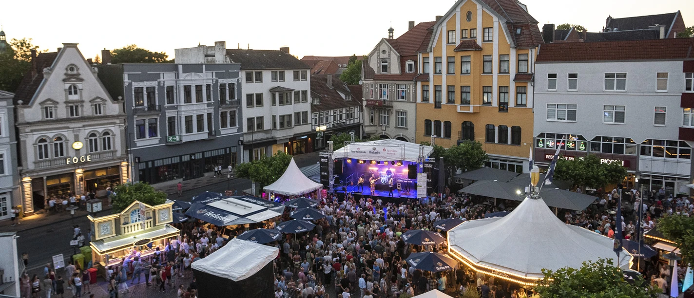 Alter Markt - Herford Hoekerfest-Pro Herford GmbH.jpg Menschenmenge genießt ein Musikfestival auf einem städtischen Platz mit historischen Gebäuden im Hintergrund.