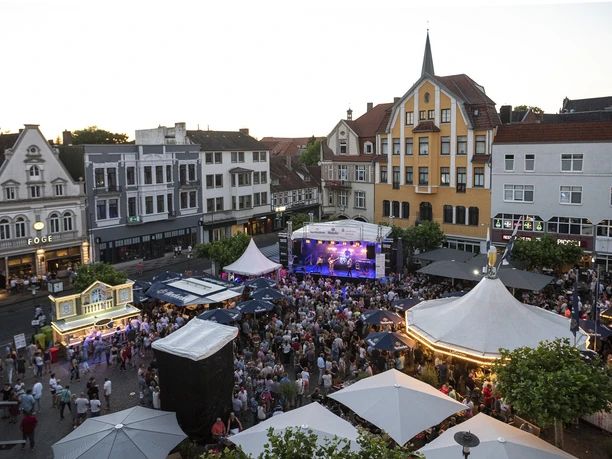 Alter Markt - Herford Hoekerfest-Pro Herford GmbH.jpg Menschenmenge genießt ein Musikfestival auf einem städtischen Platz mit historischen Gebäuden im Hintergrund.