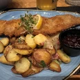 Wiener Schnitzel mit Bratkartoffeln Ein knuspriges Wiener Schnitzel begleitet von goldbraunen Bratkartoffeln und Preiselbeeren.