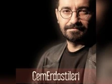 Porträtfoto von einem Mann mit Bart und Brille vor einem dunklen Hintergrund.