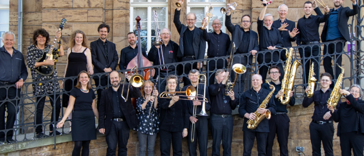 HappySwing_10-05-2025_web.jpg Eine Gruppe von Musikern steht lächelnd auf einer Treppe eines historischen Gebäudes. Sie halten Instrumente.