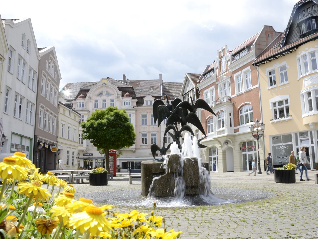 Gänsemarkt_2011_Siwinski_1.jpg Brunnen mit Skulpturen in belebtem Platz; historische Gebäude umgeben die Szene, Blumen im Vordergrund.