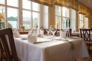 Gasthof Potthoff_004.jpg Ein helles, einladendes Restaurant mit elegant gedeckten Tischen und großen Fenstern im Hintergrund.