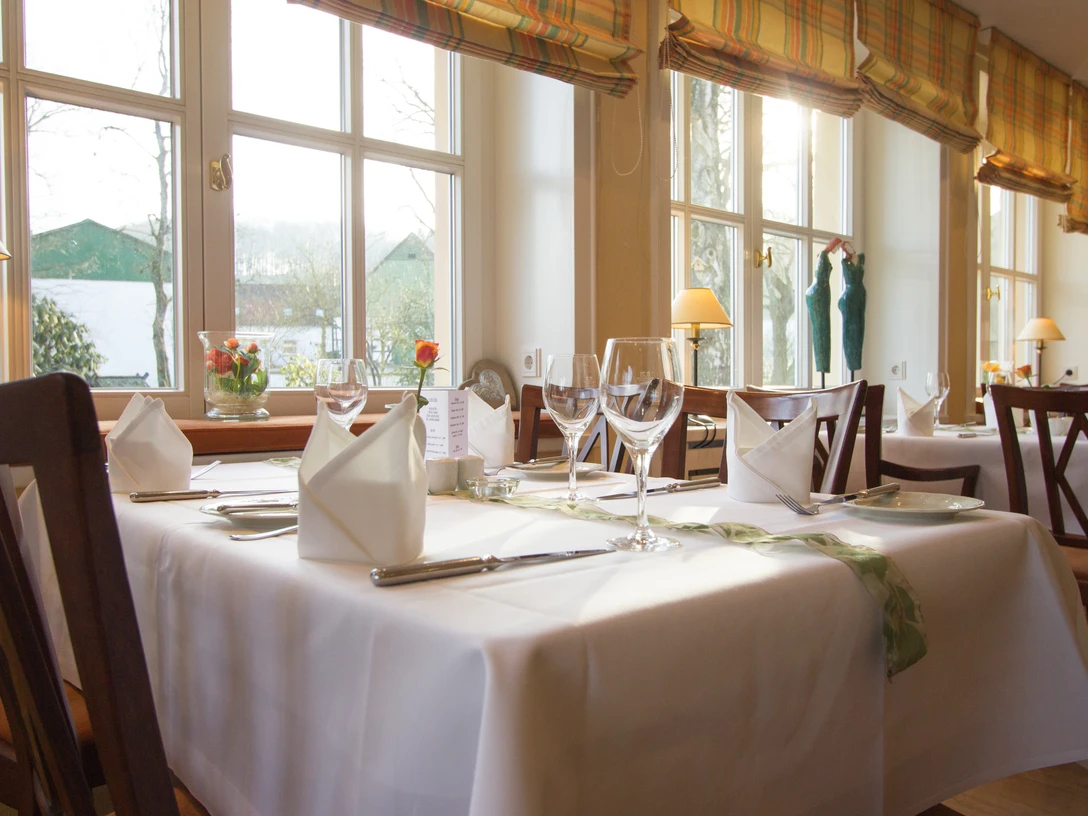 Gasthof Potthoff_004.jpg Ein helles, einladendes Restaurant mit elegant gedeckten Tischen und großen Fenstern im Hintergrund.