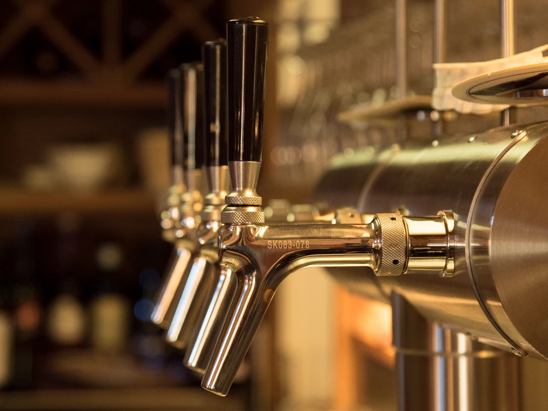 Haus Hagemeyer-Singenstroth Reihen von glänzenden Bierzapfanlagen mit dunklen Griffen in einem stimmungsvollen Gastraum.