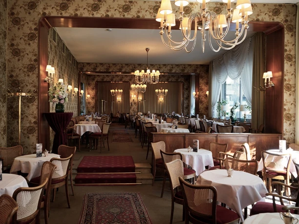 Cafe Wahlen Ein Café im 50er Jahre Stil mit Kronleuchtern und floralen Tapeten.