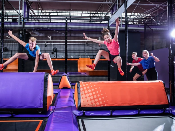 Two young people jump over an obstacle at JUMP House Leipzig, Leisure, Family, Excursion