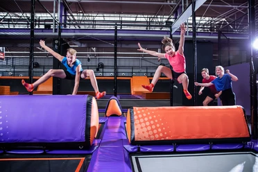 Dwoje młodych ludzi skacze przez przeszkodę w JUMP House Leipzig, Czas wolny, Rodzina, Wycieczka