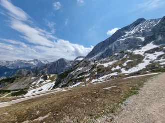 Weg von der Hochalm zum Osterfelderkopf Schneefelder und Felsmassive über einem Bergpfad unter blauem Himmel in alpiner Landschaft