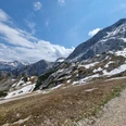Weg von der Hochalm zum Osterfelderkopf Schneefelder und Felsmassive über einem Bergpfad unter blauem Himmel in alpiner Landschaft