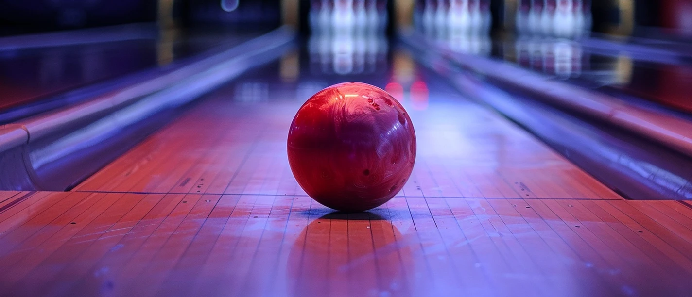 Rode bowlingbal op een verlichte bowlingbaan, op de achtergrond zijn vage bowlingkegels te zien, de sfeer is levendig en kleurrijk.