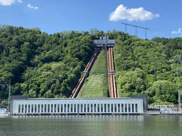 Hengsteysee Hagen.jpg Kraftwerk Koepchenwerk am Hengsteysee, umgeben von grünen Hügeln unter blauem Himmel mit weißen Wolken.