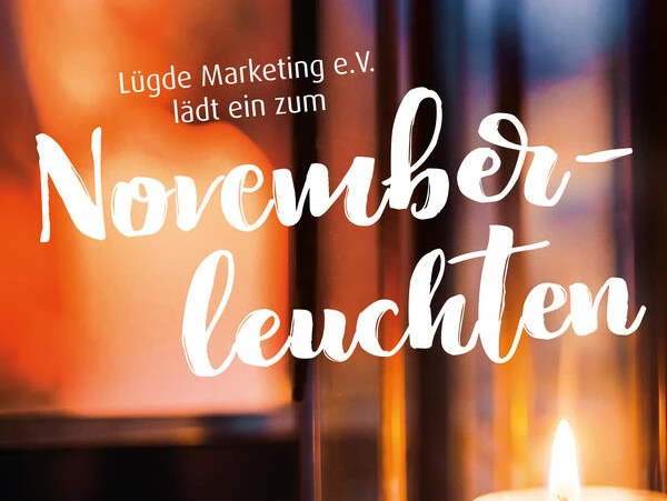 Kerze in Laterne strahlt warmes Licht aus, Hintergrund zeigt Einladung zu "Novemberleuchten".