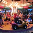 weihnachtsmarkt_lügde.JPG Kinder genießen eine fröhliche Fahrt auf einem hell erleuchteten Karussell bei einem Weihnachtsmarkt.