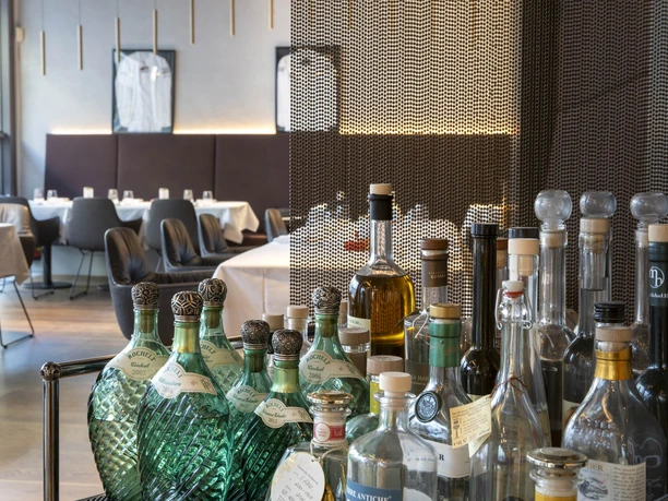 Restaurant Maximilian Lorenz The Maximilian Lorenz restaurant in Cologne, stylishly furnished with elegant seating areas and a foreground filled with fine bottles of drinks.