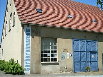 gerbereimuseum.jpg Historische Gerberei mit Satteldach, großen Fenstern und blauer Eingangstür, sonniger Wetterhimmel.