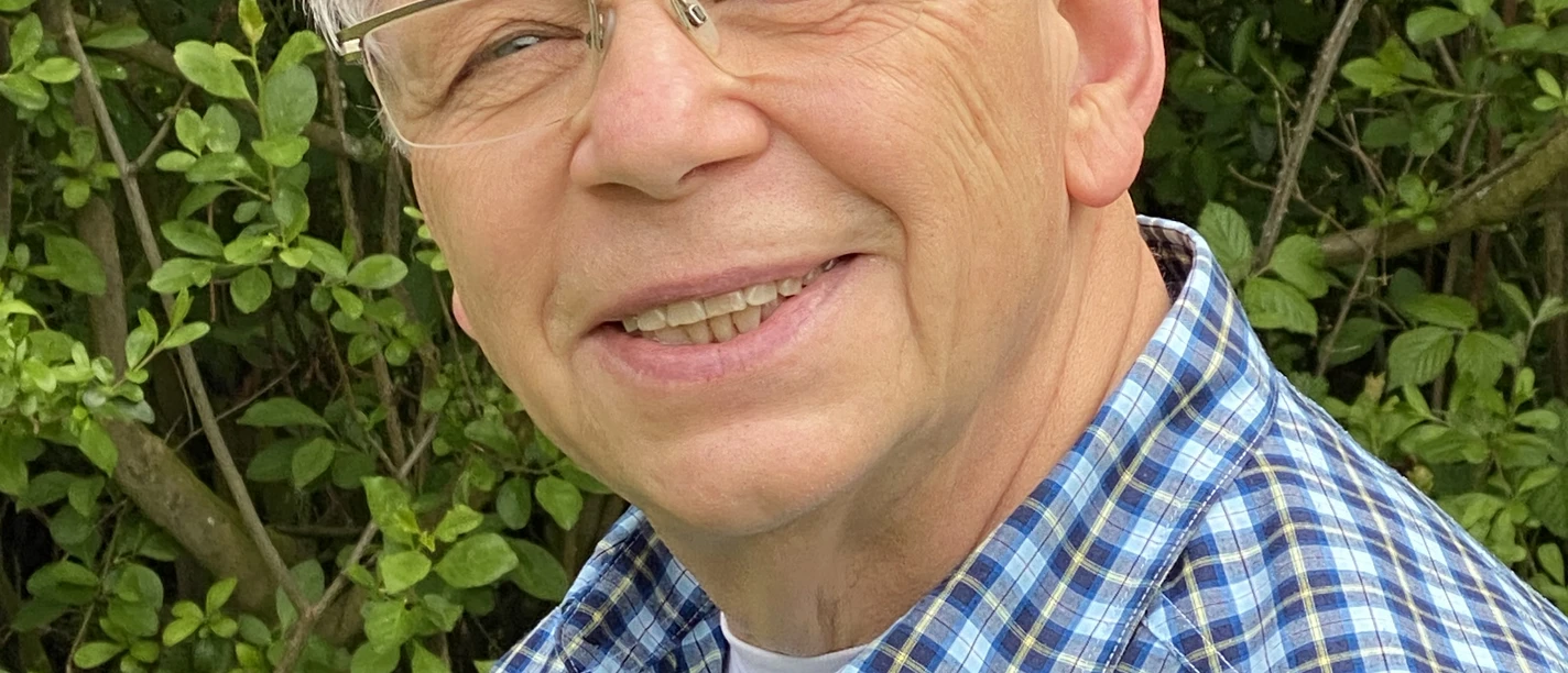 Karl-Heinz Galling.jpg Ein älterer Mann mit Brille lächelt freundlich in die Kamera, umgeben von grünen Büschen.