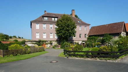 Gutshof ehemaliges Herrenhaus.jpg Mit Sandsteinschindeln verkleidetes Herrenhaus Lütmarsen