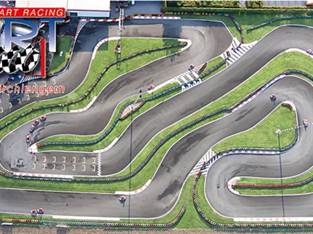 Luftaufnahme einer kurvenreichen Outdoor-Kartbahn mit mehreren Streckenabschnitten und grüner Umgebung.