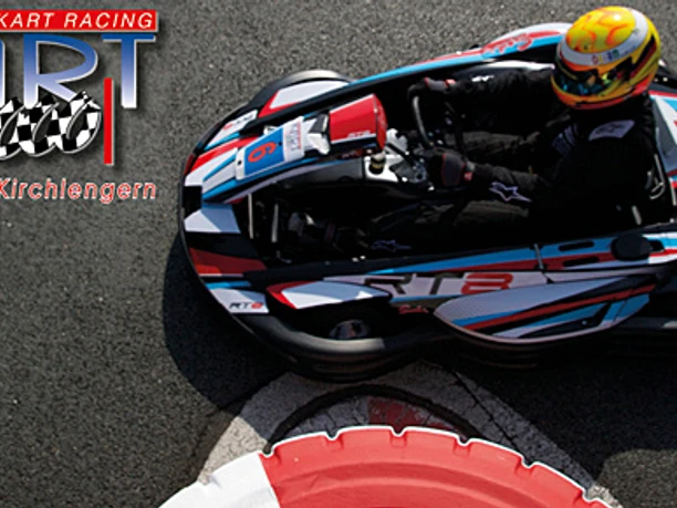 Kartfahrer bei Kurve auf der Outdoor-Kartbahn Kirchlengern mit rot-weißem Streckenrand.