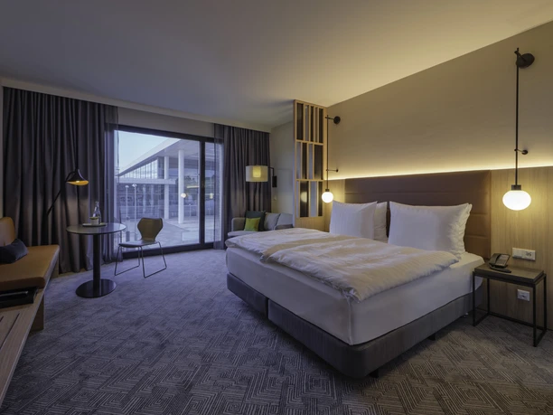 Adina-Hotel-Room Helles Hotelzimmer mit großen Fenstern und Doppelbett, modern eingerichtet für einen angenehmen Aufenthalt.