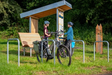 rastplatz_tonenburg_Henning_Orendt (2).jpg Pärchen an einem Fahrradrastplatz mit Holzunterstand, Fahrradanlehnbügeln mit einem Fahrrad, Sitzmöglichkeit