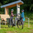 rastplatz_tonenburg_Henning_Orendt (2).jpg Pärchen an einem Fahrradrastplatz mit Holzunterstand, Fahrradanlehnbügeln mit einem Fahrrad, Sitzmöglichkeit