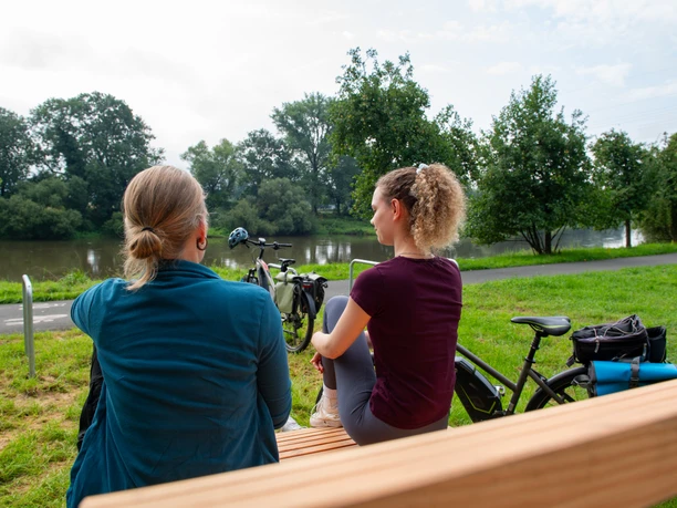 rastplatz_tonenburg_Henning_Orendt (9).jpg Zwei Frauen auf einer Bank mit Blick zur Weser und Fahrrädern