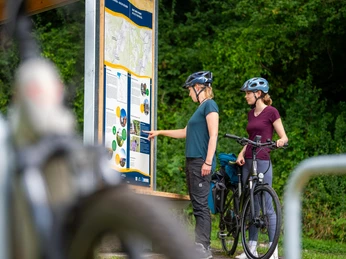 rastplatz_tonenburg_Henning_Orendt (18).jpg Zwei Frauen mit Fahrrädern vor Infotafel