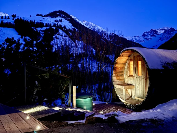 Tonneau de sauna près du Hubel Hüsi Sauna en tonneau éclairé à l'extérieur la nuit