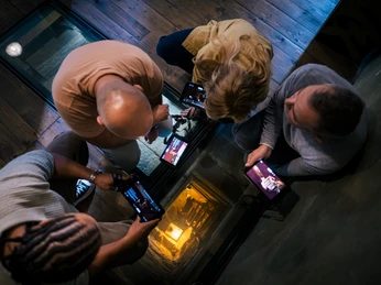 Schloss Colditz - Sehenswürdigkeiten in der Leipzig Region Aus der Vogelperspektive schauen wir auf mehrere Personen, die mit ihren HistoPads den Rundgang des Museums im Schloss Colditz durchlaufen, Sie befinden sich am Tunnel, der ausgeleuchtet wird, um die Tiefe zu erkennen, Schlösserland Sachsen, Ausflug