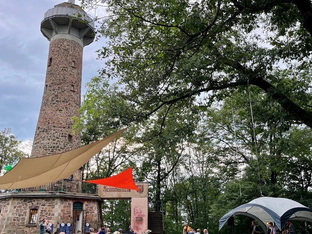 Zdjęcie przedstawia wieżę mieszkalną w Colditz i gości robiących sobie krótką przerwę i cieszących się idyllicznym otoczeniem.